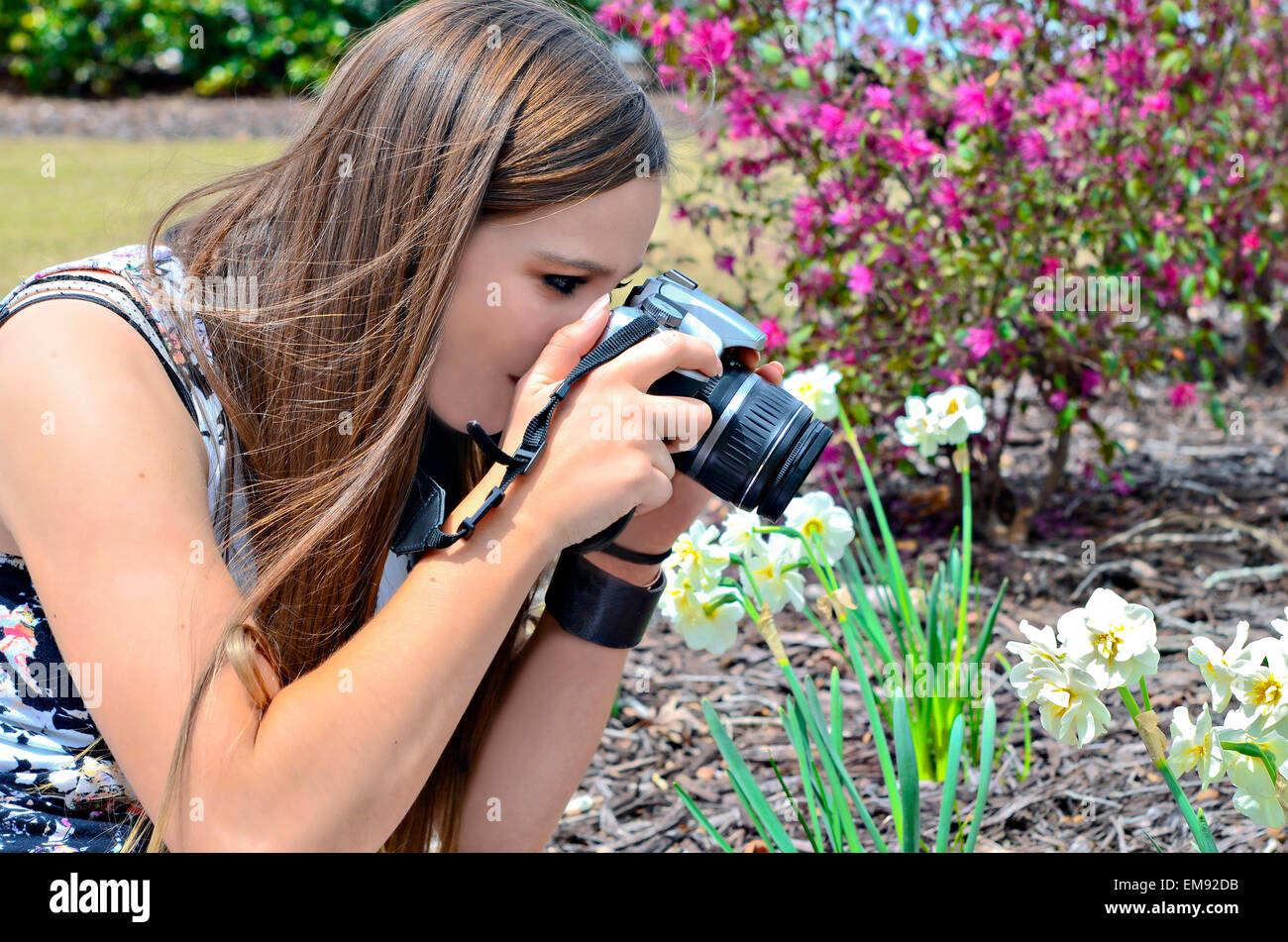 Un adolescent de prendre une photo de son jardin de fleurs. Banque D'Images