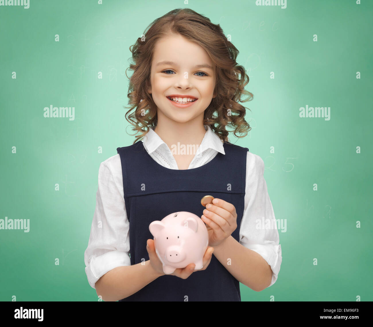 Happy girl holding piggy bank and coins Banque D'Images