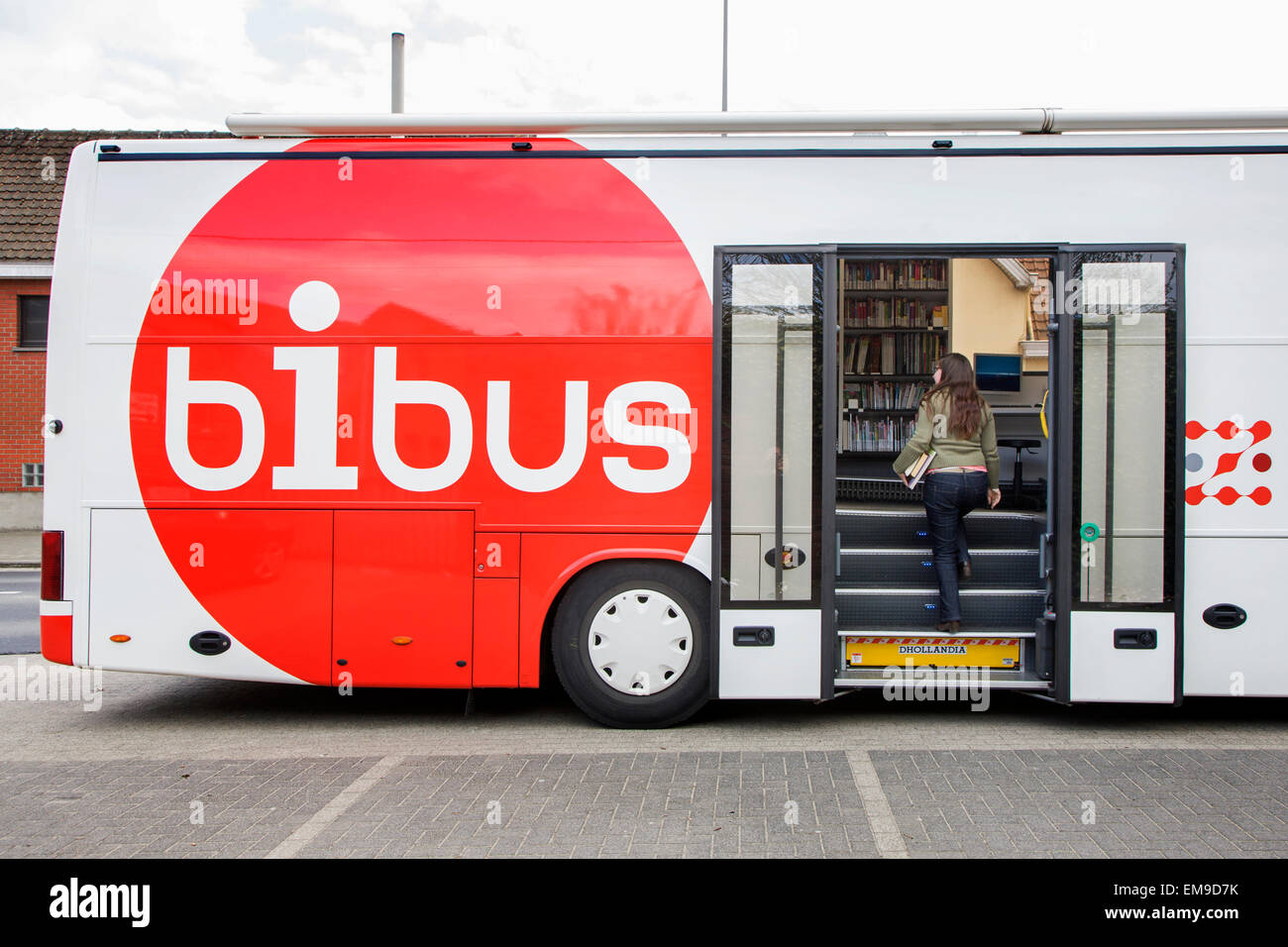 Fille de retourner les livres dans la bibliothèque mobile, Bibus bus en Flandre orientale, Belgique Banque D'Images
