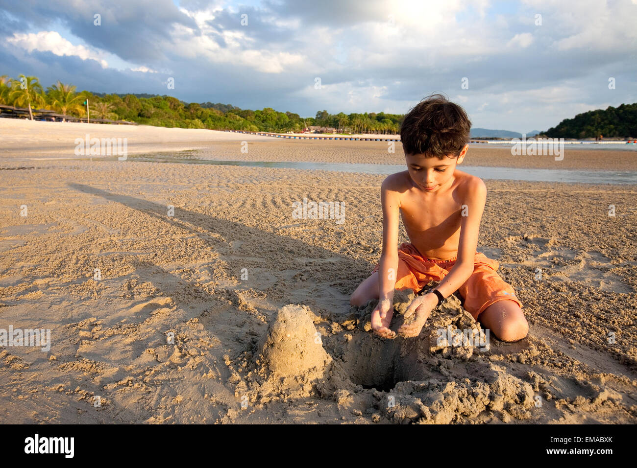 Jeune garçon jouer dans le sable à une plage tropicale Banque D'Images