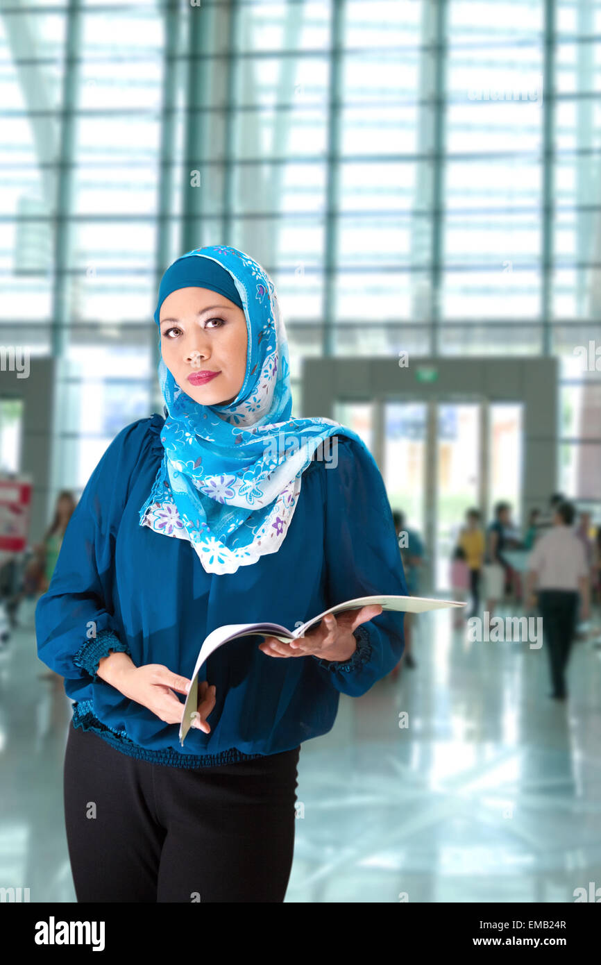 Une femme musulmane avec un livre dans le hall d'exposition Banque D'Images