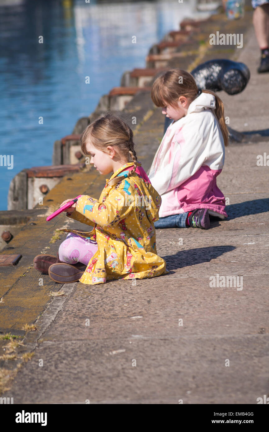 Poole, Dorset, UK 19 avril 2015. UK - sunny breezy day à Poole Quay, Dorset, UK - deux jeunes filles jouissent en crabe sur le quai Crédit : Carolyn Jenkins/Alamy Live News Banque D'Images