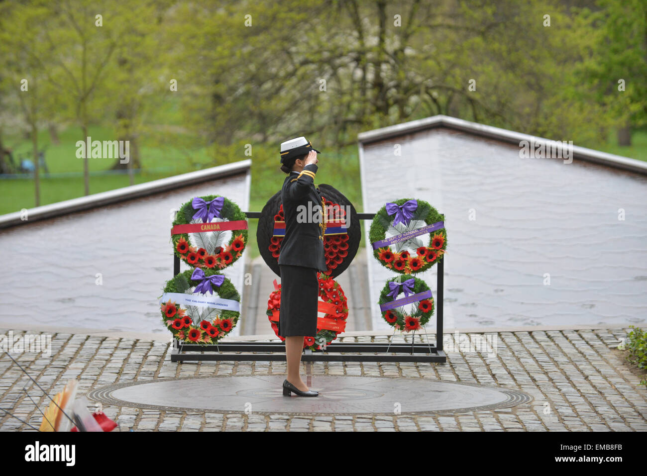 Green Park, London, UK. 19 avril 2015. Couronnes portées au Monument commémoratif de guerre du Canada à Green Park. Un soldat salue comme l'Union Jack est abaissée. Les régiments et vous montez au Monument commémoratif de guerre du Canada à Green Park pour une cérémonie et dépôt de gerbe. Trois régiments canadiens commémorent leurs rôles dans la deuxième bataille d'Ypres de WW1 qui a eu lieu il y a 100 ans. La bataille fut la première fois que l'Allemagne utilisé des armes chimiques à grande échelle. Crédit : Matthieu Chattle/Alamy Live News Banque D'Images
