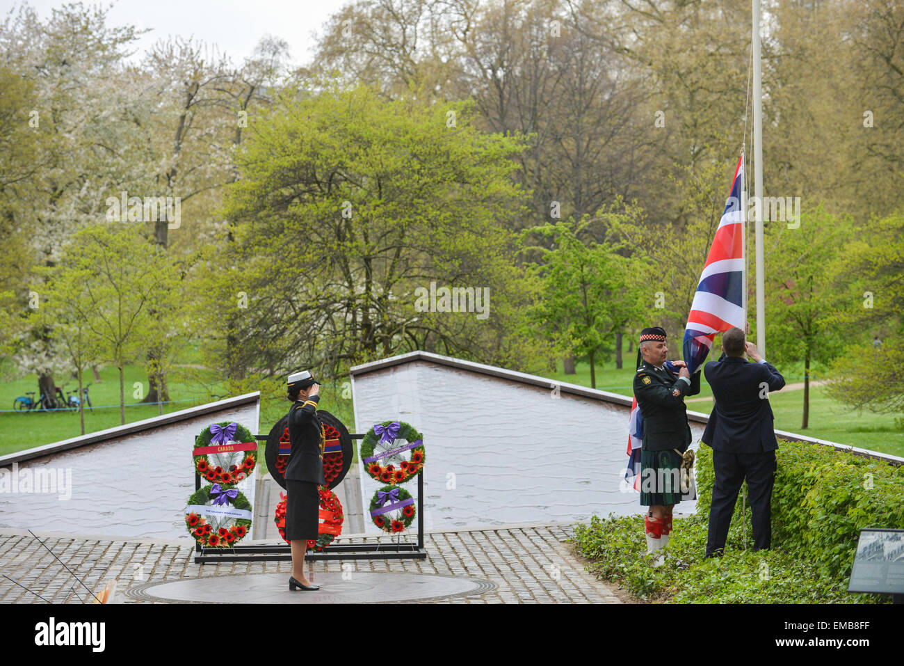 Green Park, London, UK. 19 avril 2015. Couronnes portées au Monument commémoratif de guerre du Canada à Green Park. Un soldat salue comme l'Union Jack est abaissée. Les régiments et vous montez au Monument commémoratif de guerre du Canada à Green Park pour une cérémonie et dépôt de gerbe. Trois régiments canadiens commémorent leurs rôles dans la deuxième bataille d'Ypres de WW1 qui a eu lieu il y a 100 ans. La bataille fut la première fois que l'Allemagne utilisé des armes chimiques à grande échelle. Crédit : Matthieu Chattle/Alamy Live News Banque D'Images