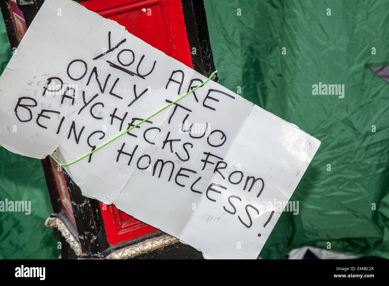 Manchester, Royaume-Uni 19th avril 2015. ' Vous n'êtes que deux chèques de paie d'être sans-abri' papier écrit main signe. Les militants sans emploi continuent de se tenir à l'extérieur de l'hôtel de ville de Manchester pour faire prendre conscience de la crise du logement temporaire. Les manifestants dorment dans des tentes dans un campement de la place Albert ; beaucoup ont récemment été libérés de prison et n'ont aucun espoir d'accommodement. Le groupe, appelé les droits des sans-abri de la justice, ont une comparution lundi pour être expulsés, ils auront 48 heures pour partir. Banque D'Images