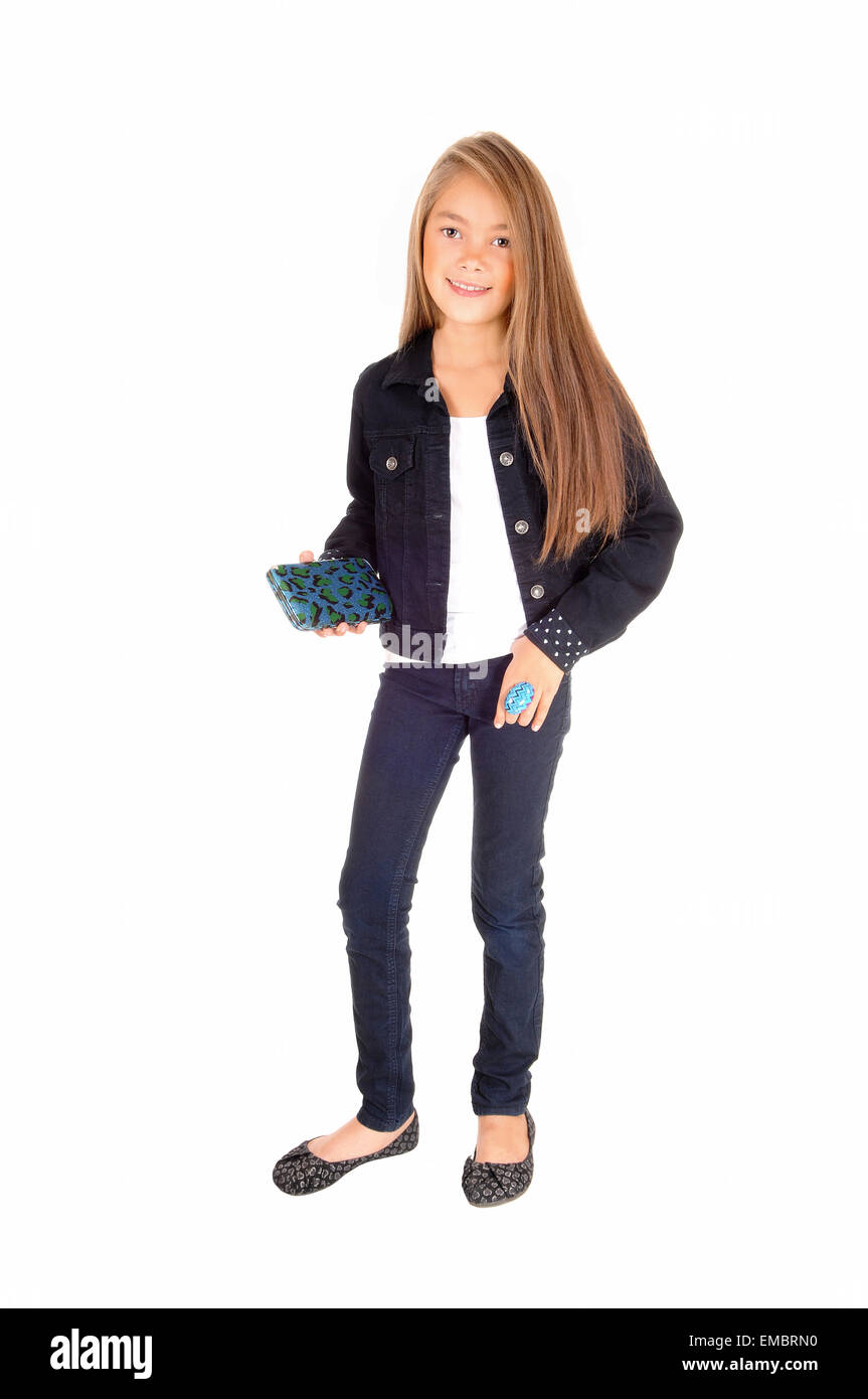 Une jolie fillette de huit ans isolés pour fond blanc en jeans et d'un jean veste, tenant son sac à main. Banque D'Images