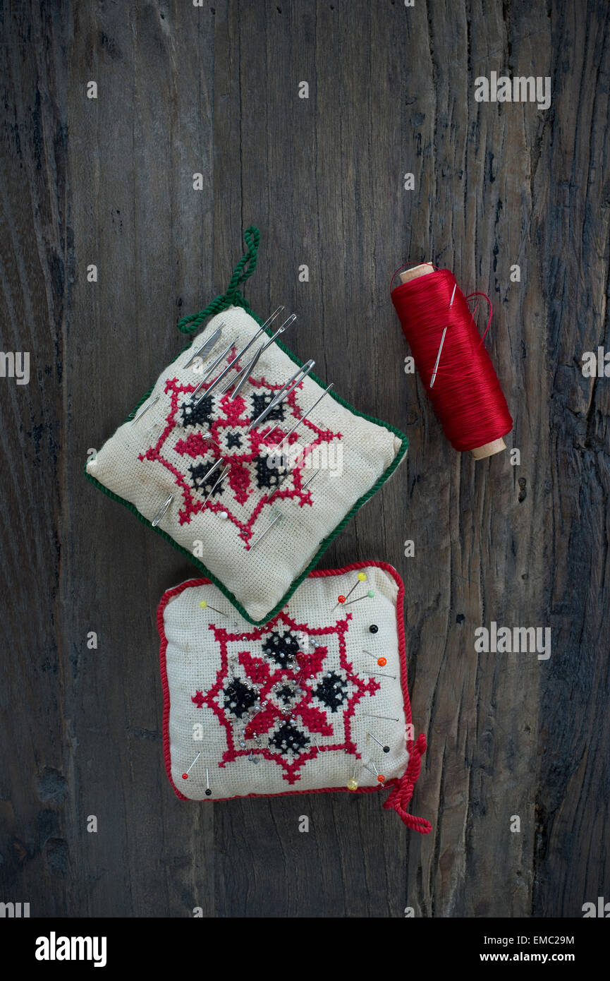 Broche deux coussins et rouleaux de coton rouge sur bois Banque D'Images