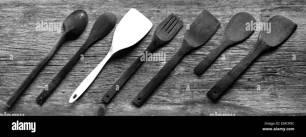 Spatules et cuillères de cuisine vintage à bord avec un comité permanent de la foule Banque D'Images