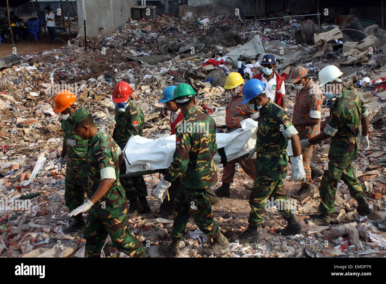 Les sauveteurs portent le corps d'une victime extrait des décombres de l'emplacement d'une usine de confection qui s'est effondré à Savar, Dhaka. Banque D'Images