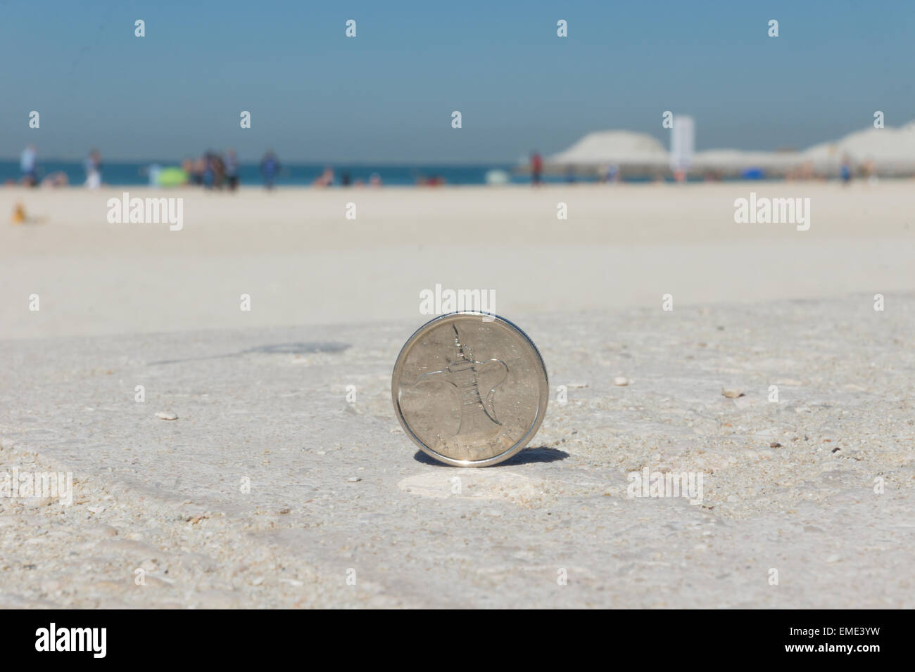 Gros plan d'une pièce de monnaie dinar argent sur une plage à Dubaï Banque D'Images