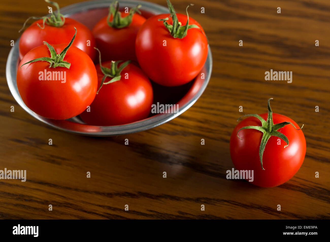 Tomates cerise mûre dans bol en métal sur fond de bois Banque D'Images