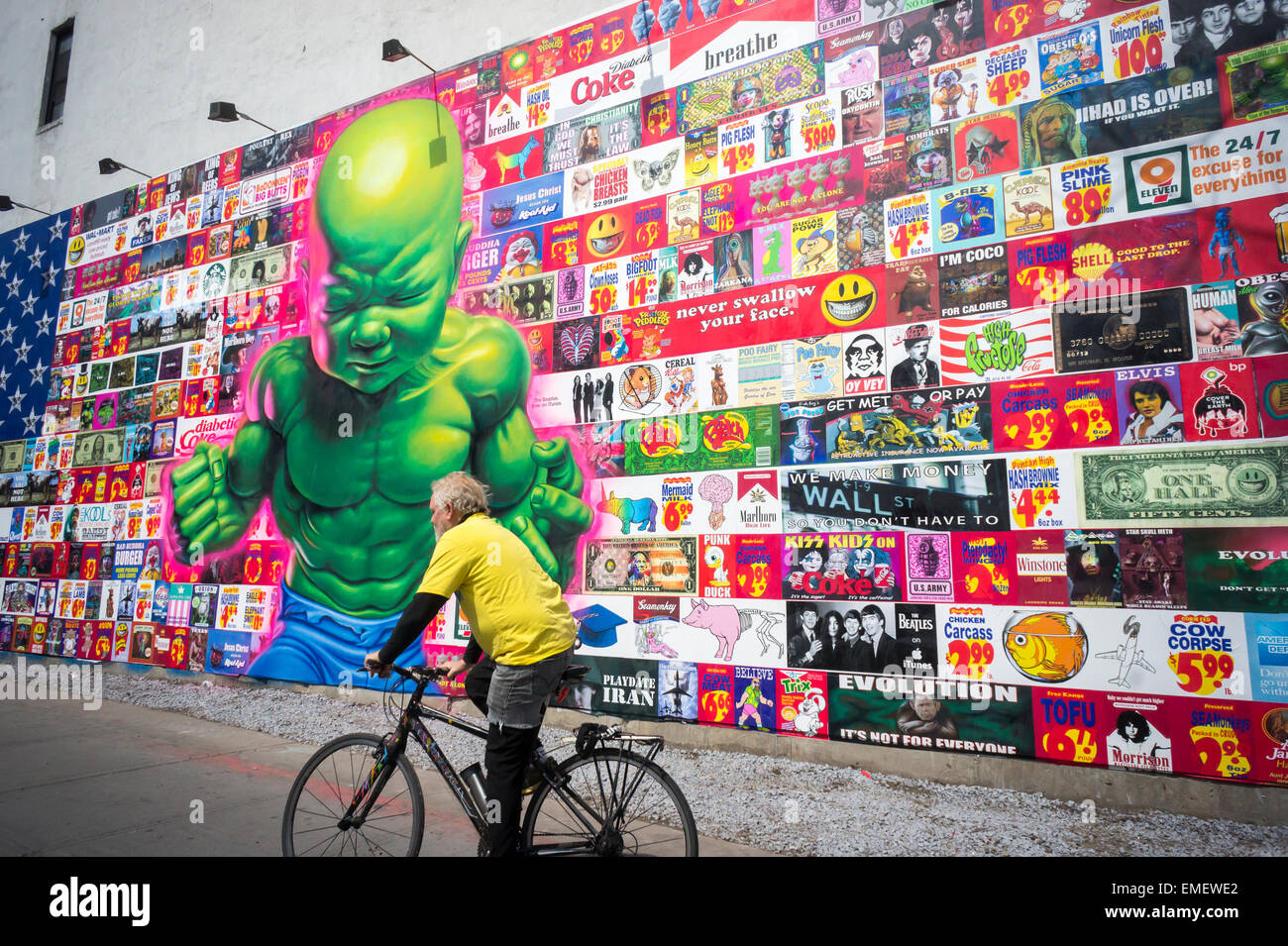 Passant admirer la nouvelle peinture murale par le célèbre artiste de rue, Ron English sur la nouvelle peinture murale Bowery à Soho, à New York, le Samedi, Avril 18, 2015. Le travail de l'anglais et critique des parodies consumérisme et c'est son premier ouvrage public dans plus d'un an. La reconstruction de l'espace, organisée par Jeffrey Deitch, est célèbre pour avoir accueilli des peintures murales réalisées par des artistes graffiti, notamment Keith Haring . (© Richard B. Levine) Banque D'Images