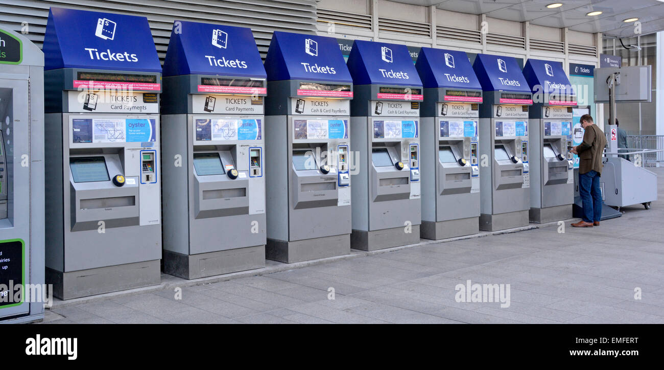 Passager de chemin de fer aux guichets en libre-service pour le paiement par carte et en espèces pour l'achat de billets de train ou de carte Oyster à la gare London Bridge, Angleterre, Royaume-Uni Banque D'Images