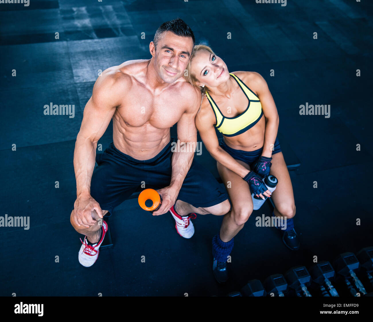 Souriant et heureux homme musclé femme sportive reposant sur l'audience à la salle de sport. Looking at camera Banque D'Images