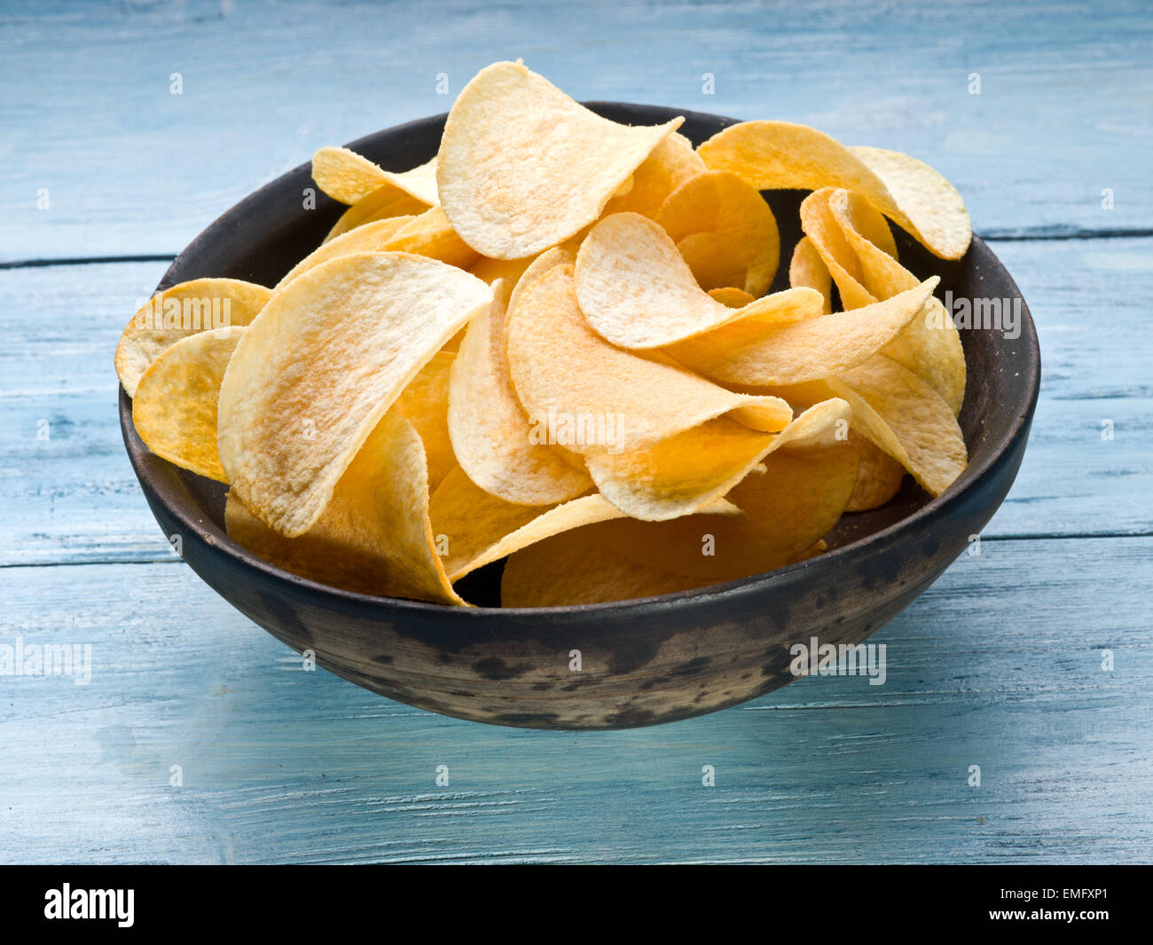 Croustilles de pommes de terre sur un fond en bois bleu. Banque D'Images