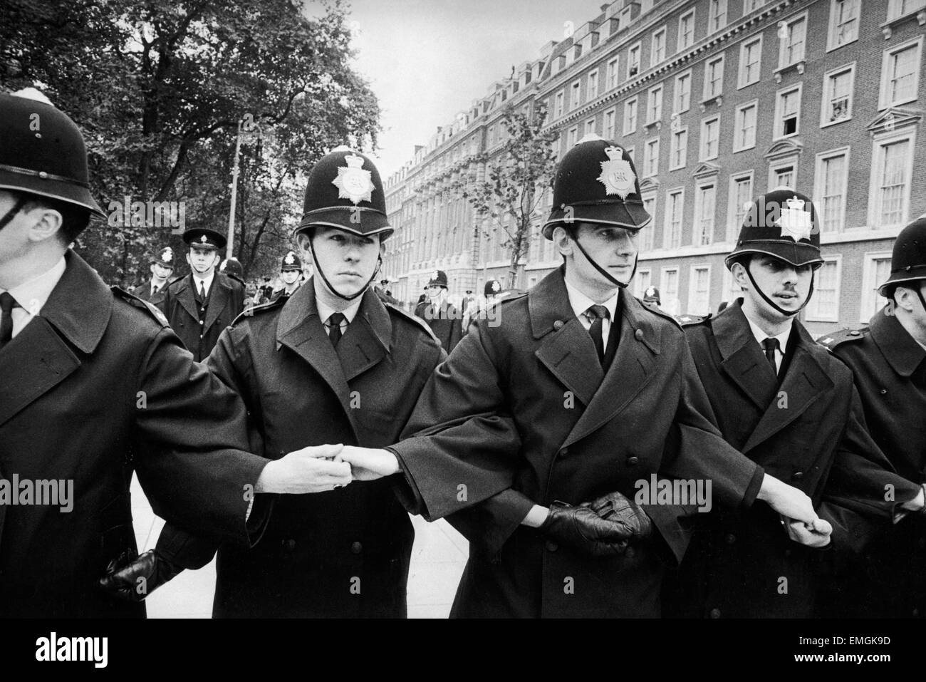 Les jeunes policiers bloquer les bras comme ils se préparent à prendre la contrainte pour les grandes foules dans Grosvenor Square Londres , lors d'un grand rassemblement anti guerre du Vietnam. 27 octobre 1968. Banque D'Images