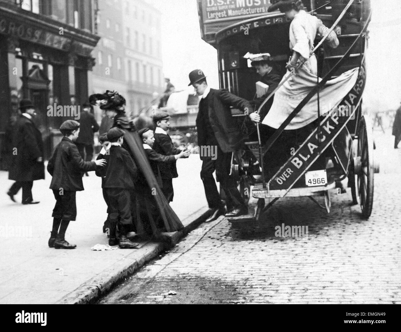 Un groupe d'enfants demandent un homme hisused kutnicki pour billet comme il descend du véhicule. Les billets ont été utilisés dans le cadre d'un miroir quotidien promtion avec un prix awardd à un billet gagnant. 22 mai 1906. Banque D'Images