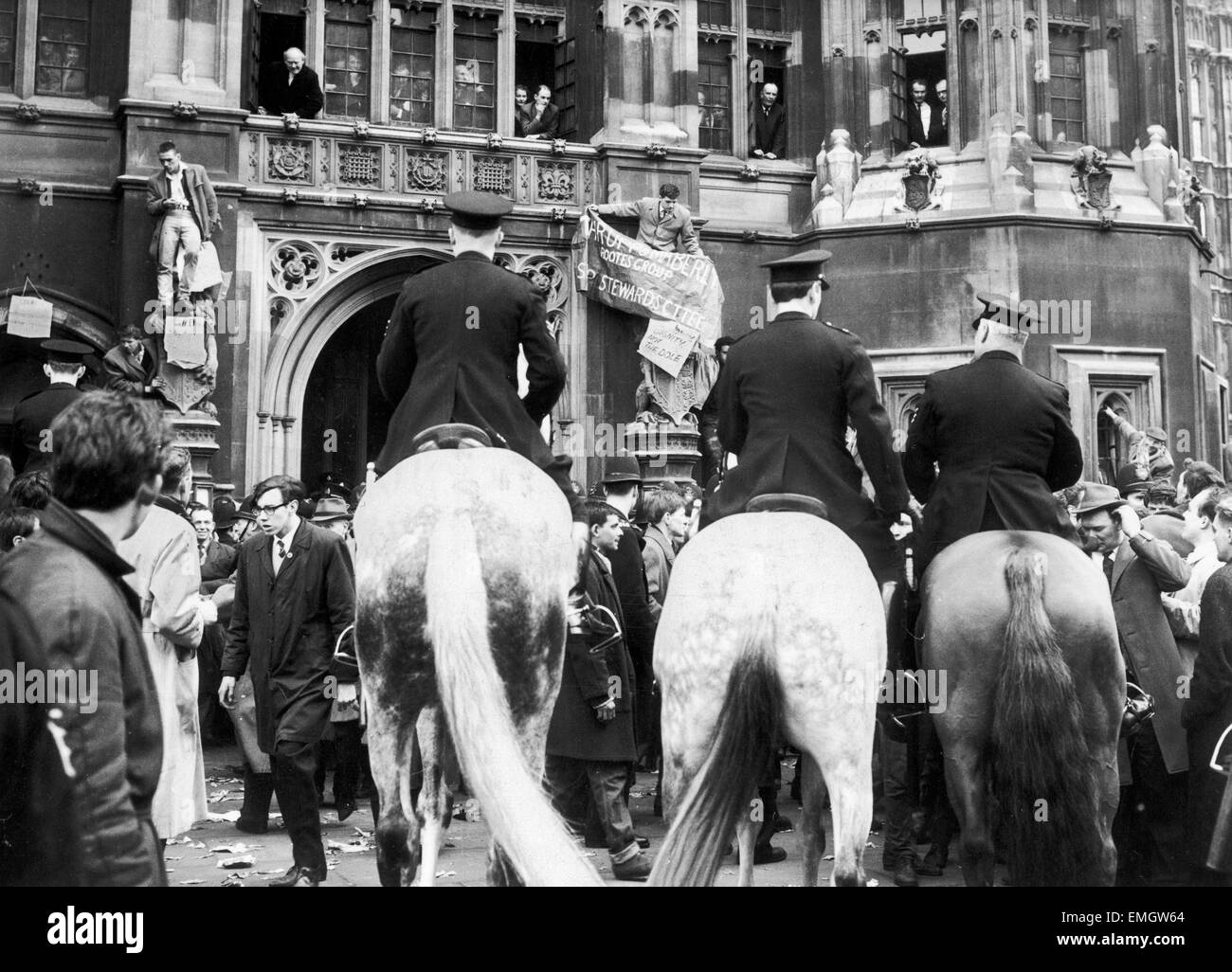 La bataille de Westminster. Canada en mouvement pour disperser une manifestation de 3000 manifestants du chômage point noir de partout dans le pays, à Westminster, les membres du Parlement de l'appartement donne sur la scène des fenêtres de la Chambre des communes. Deux des manifestants sont climbup sur les contreforts sculptés à. 26 Mars 1963 Banque D'Images La bataille de Westminster. Canada en mouvement pour disperser une manifestation de 3000 manifestants du chômage point noir de partout dans le pays, à Westminster, les membres du Parlement de l'appartement donne sur la scène des fenêtres de la Chambre des communes. Deux des manifestants sont climbup sur les contreforts sculptés à. 26 Mars 1963 Banque D'Images