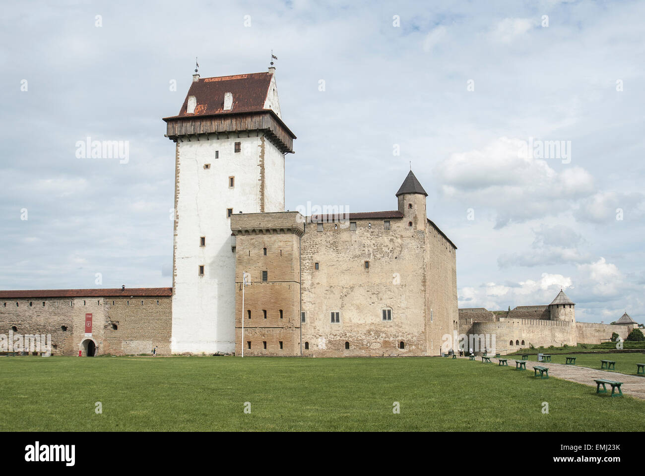 Dans le château Hermanns ville Narva en Estonie. Un château en pierre et une grande tour blanche avec un toit. Ciel nuageux et l'herbe verte. Banque D'Images
