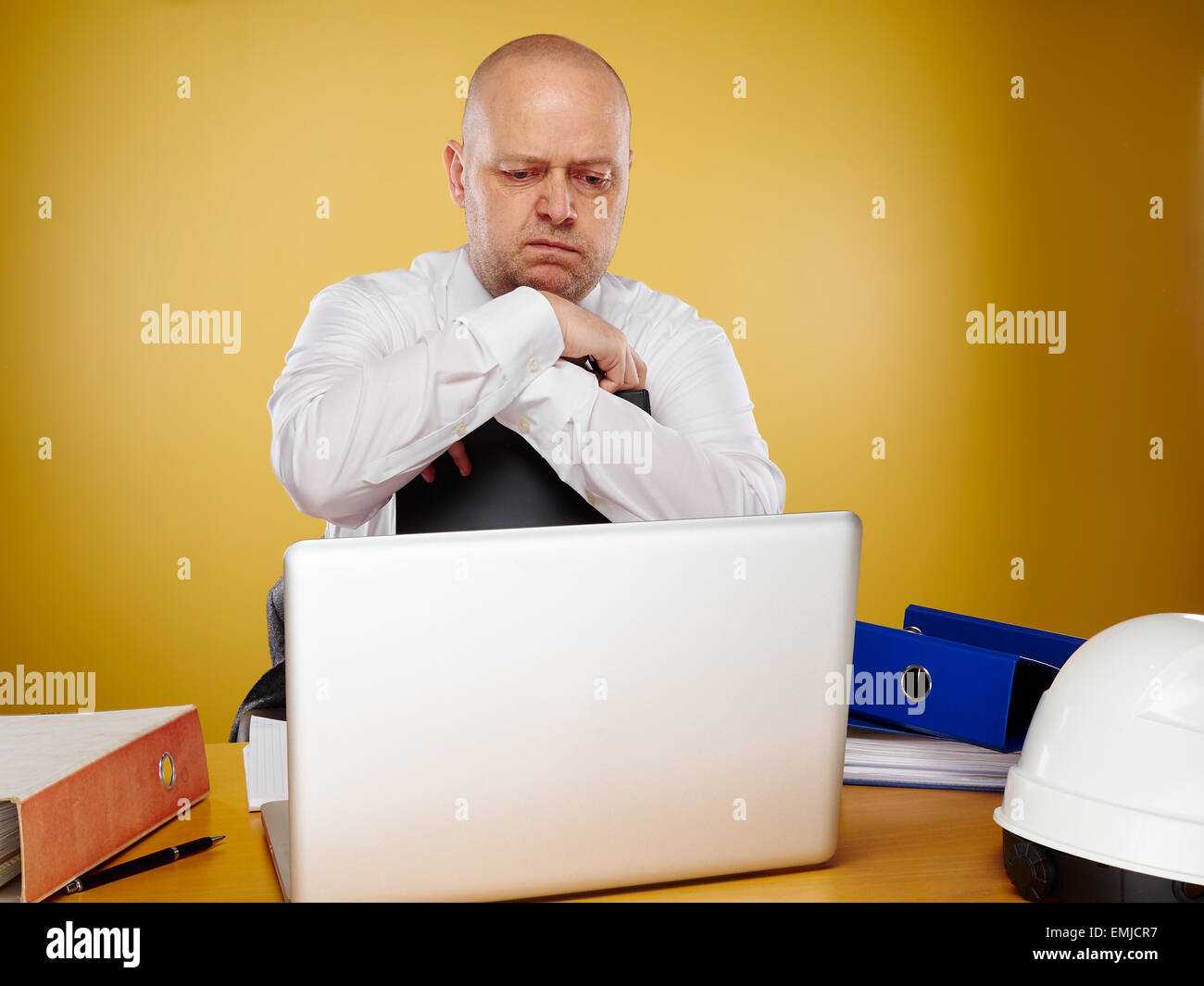 Hommes travaillants dans ingénieur bureau, il porte une chemise blanche et cravate, l'ordinateur portable, de liants et casque blanc est sur la table Banque D'Images