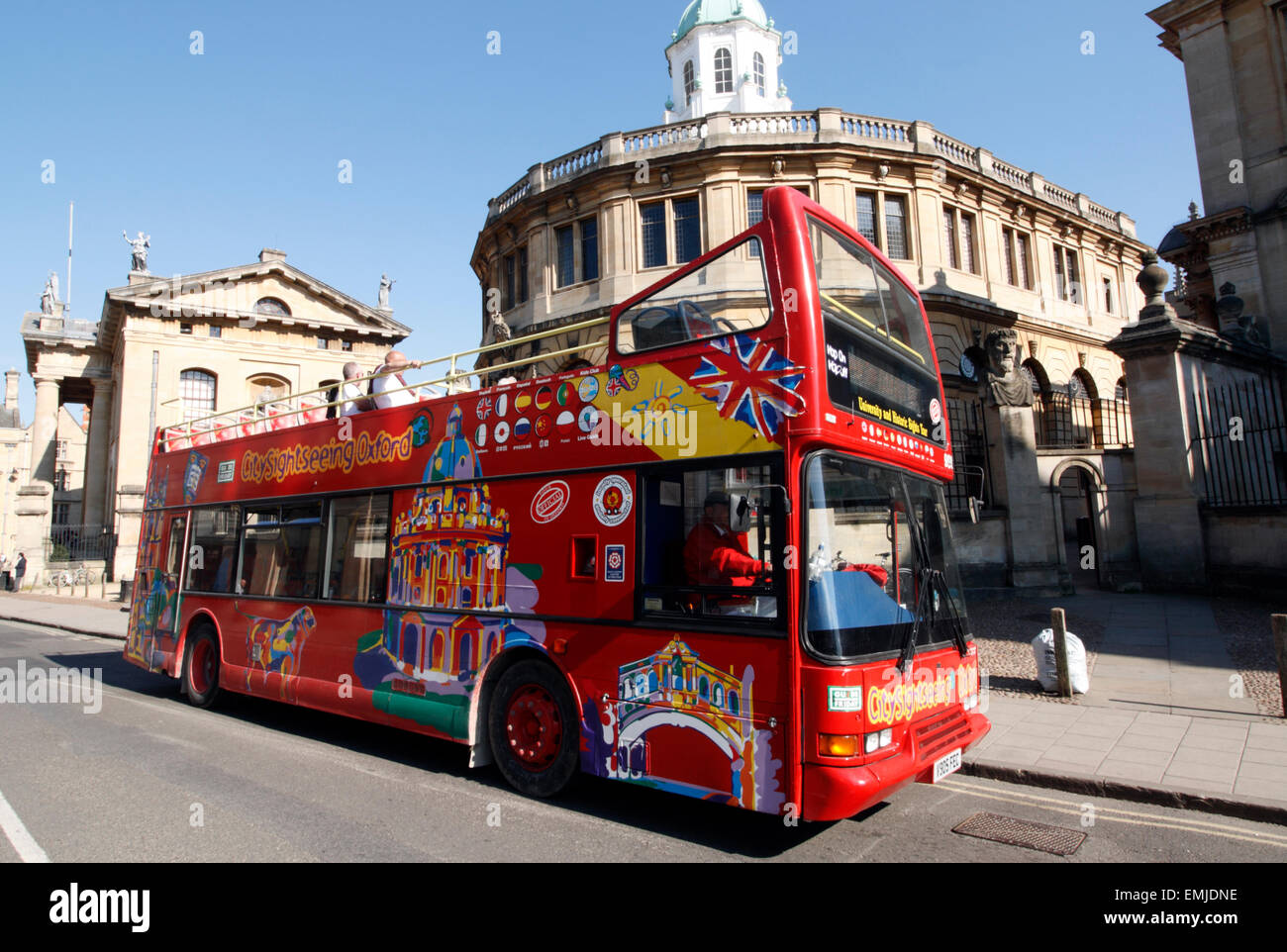 Un bus de tourisme open top rouge à l'extérieur du Sheldonian Theatre d'Oxford, Angleterre Banque D'Images