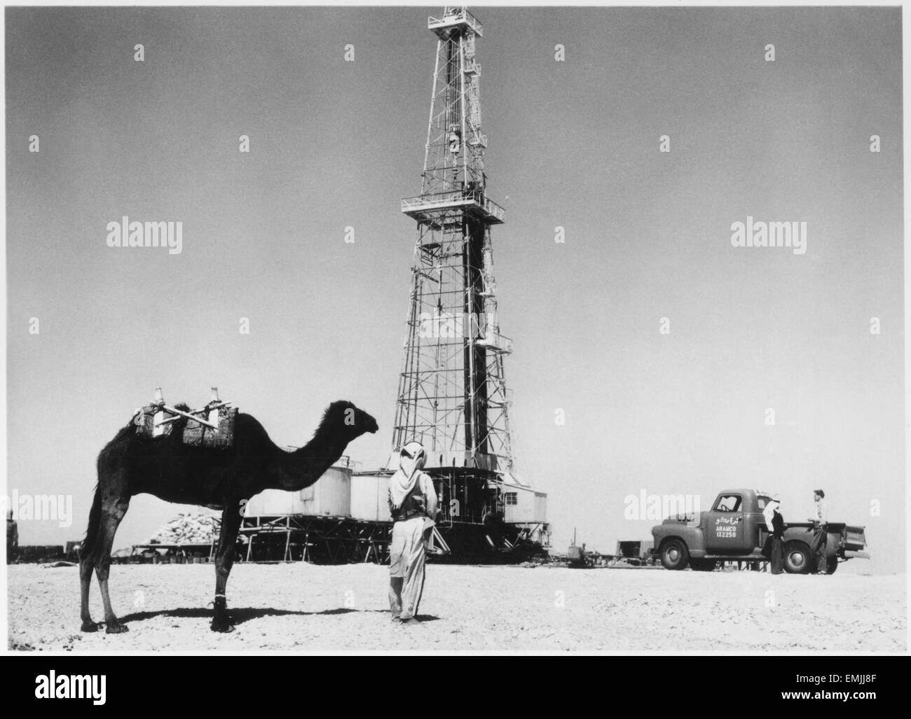 L'homme et près de chameau un puits de pétrole, l'Arabie saoudite, vers 1940 Banque D'Images