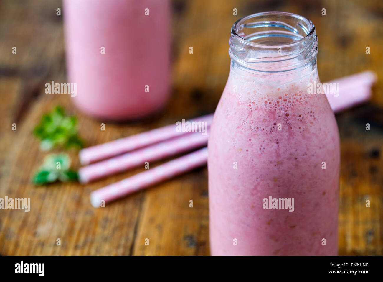 Smoothie aux framboises dans des bouteilles de lait Banque D'Images