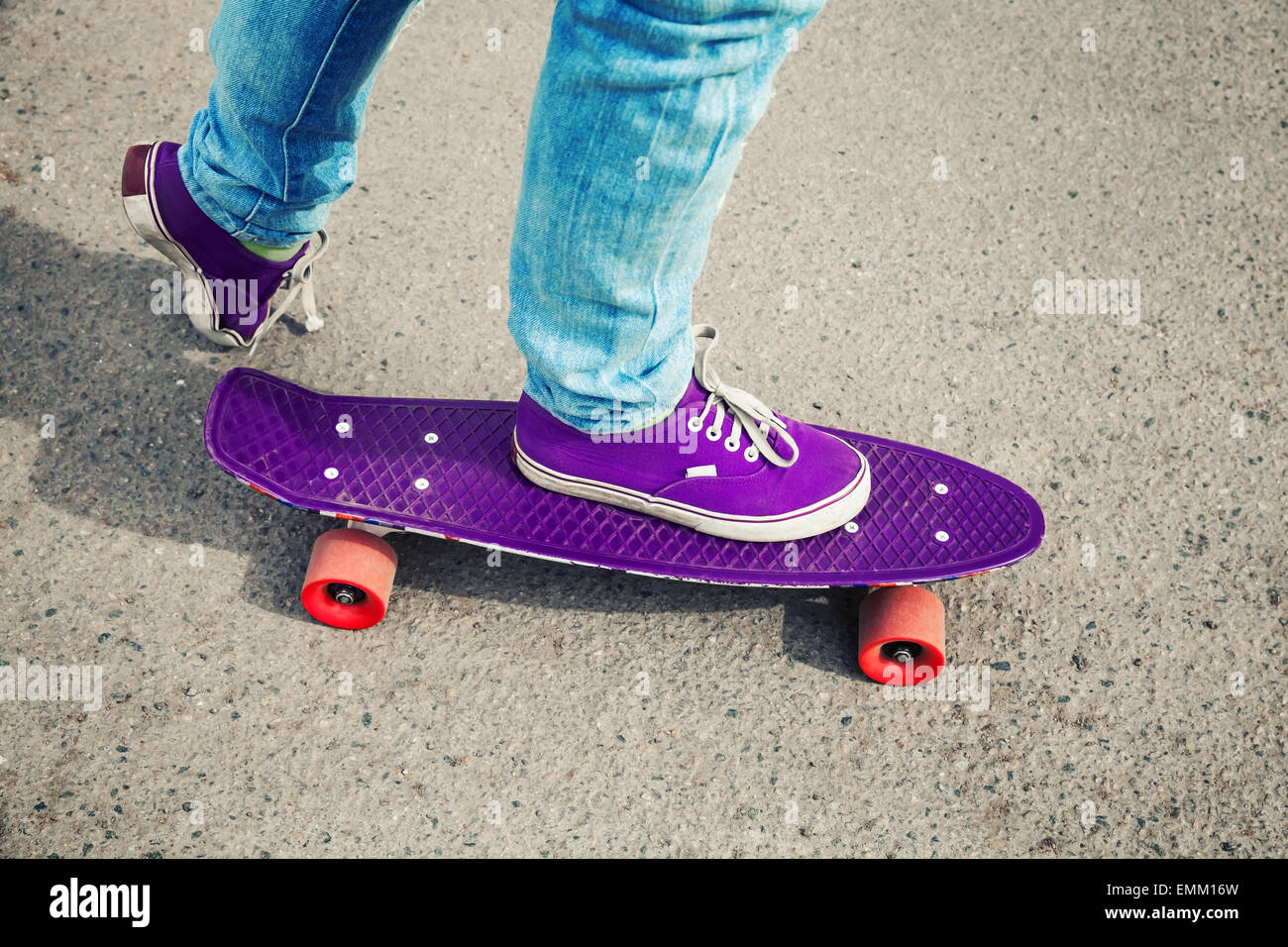 La planche en jeans, des pieds avec fragment de skate, avec photo, correction tonale retro ancien style instagram Banque D'Images