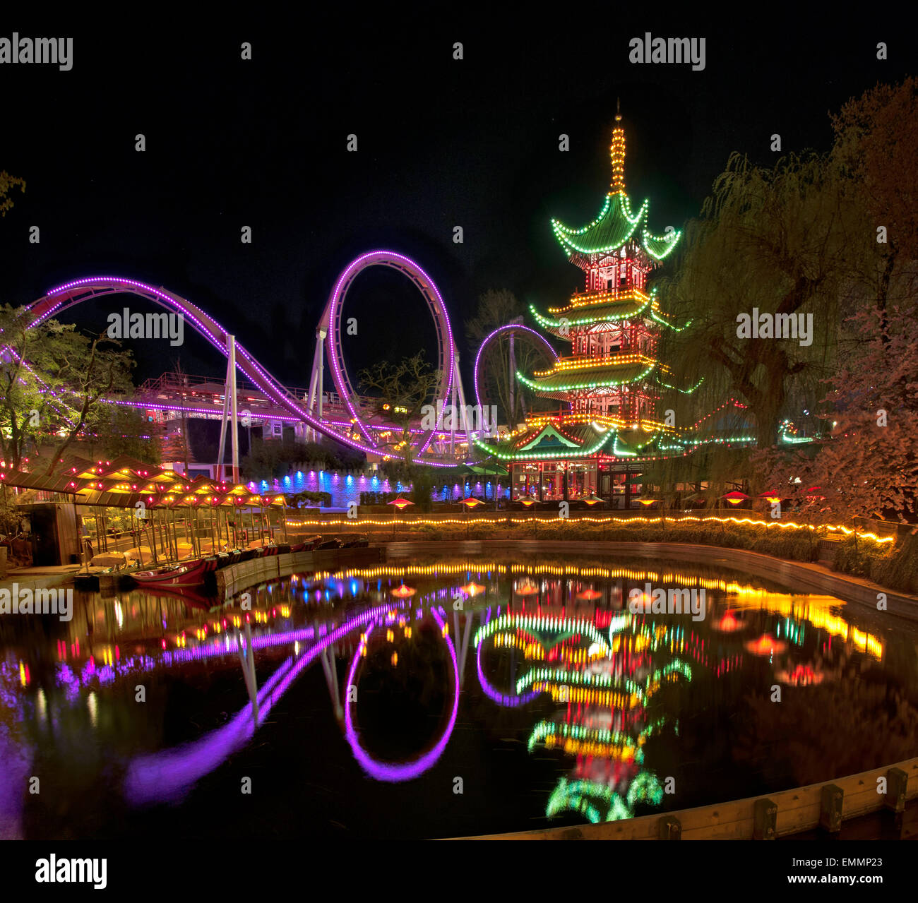 Tivoli, le parc à thème de la ville capitale Copenhague éclairés la nuit avec son reflet dans l'eau. Banque D'Images