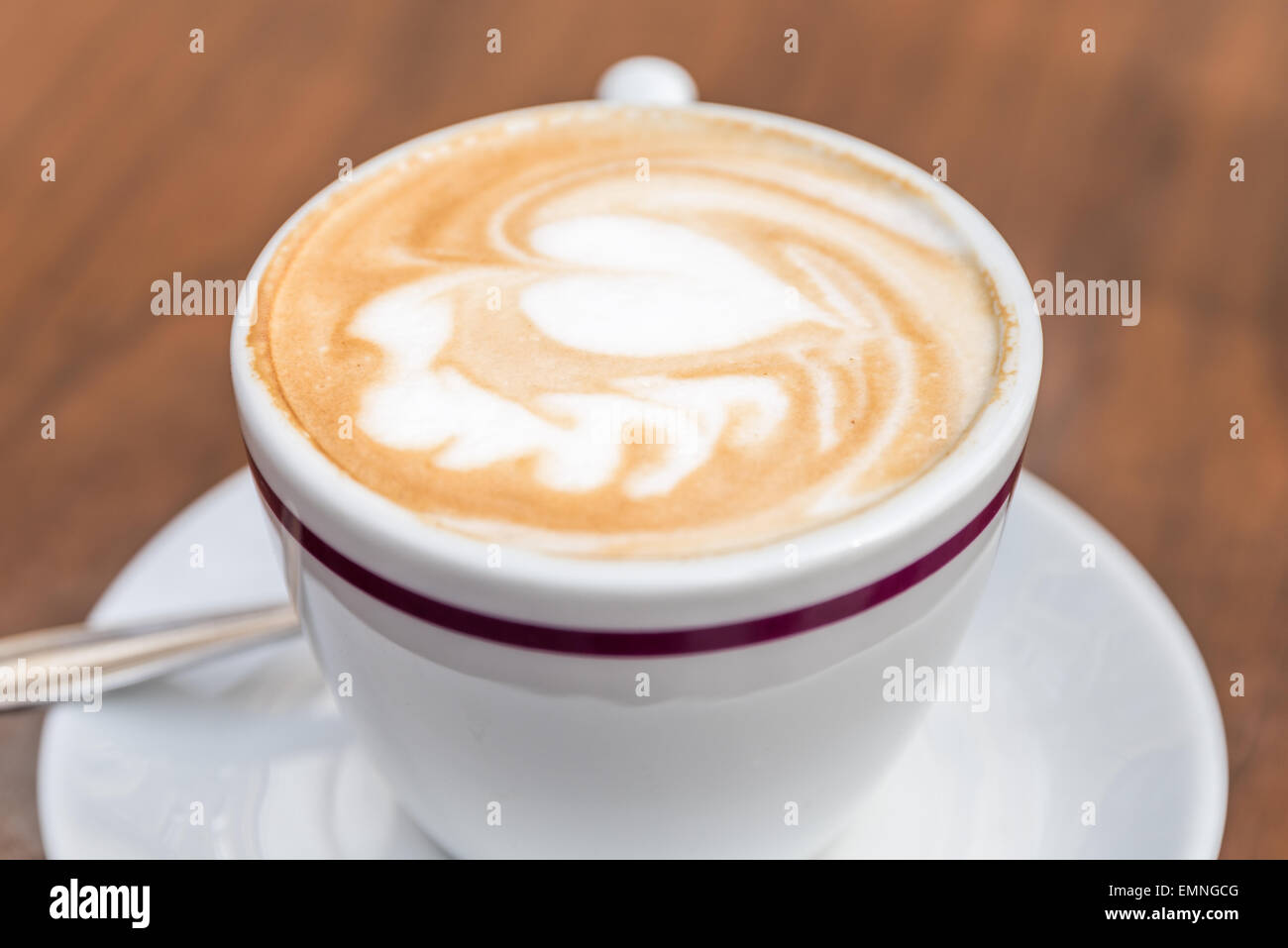 Tasse de café blanc avec motif coeur sur table en bois Banque D'Images