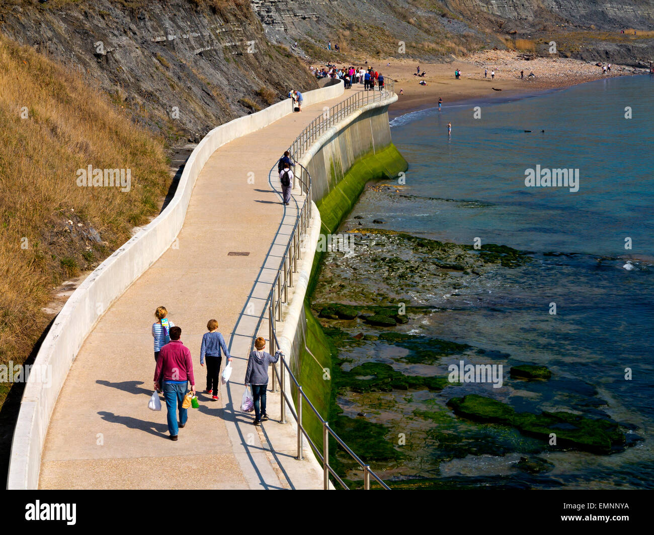 Les touristes sur la falaise est un mur de défense côtière et maritime à Lyme Regis Dorset England UK construit 2014 pour empêcher l'érosion côtière Banque D'Images