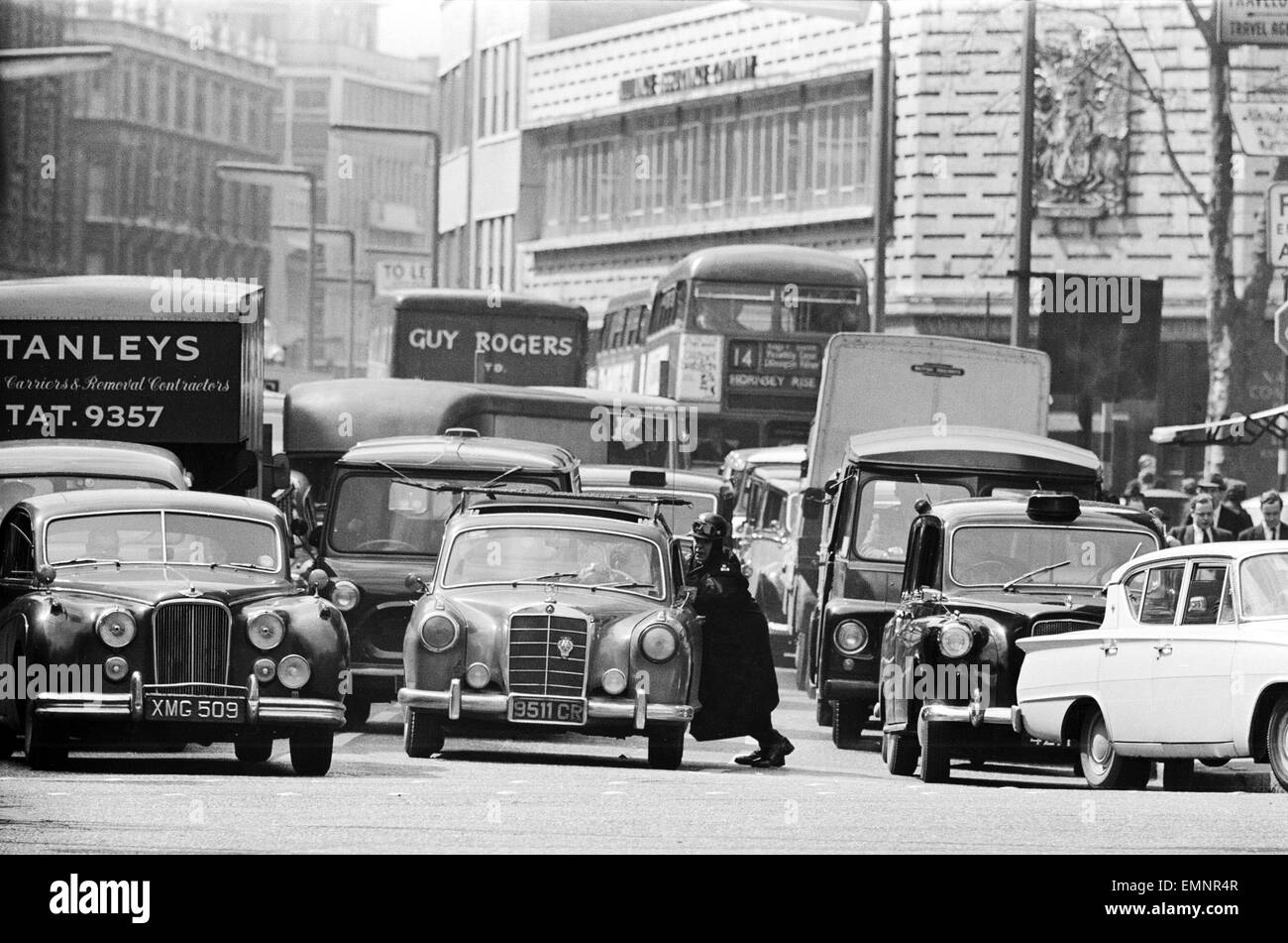 Scènes de Knightsbridge, le centre de Londres après une voiture en panne dans la route causant un hold up. 23 avril 1964. Banque D'Images