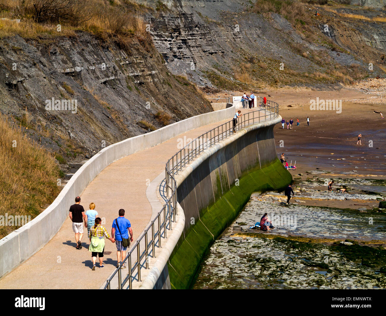 Les touristes sur la falaise est un mur de défense côtière et maritime à Lyme Regis Dorset England UK construit 2014 pour empêcher l'érosion côtière Banque D'Images