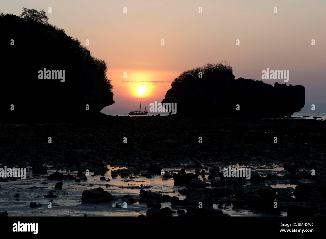 Coucher du soleil entre les rochers, le soleil naufrage sur un bateau dans la mer d'Andaman près de Koh Poda dans la province de Krabi, Thaïlande Banque D'Images