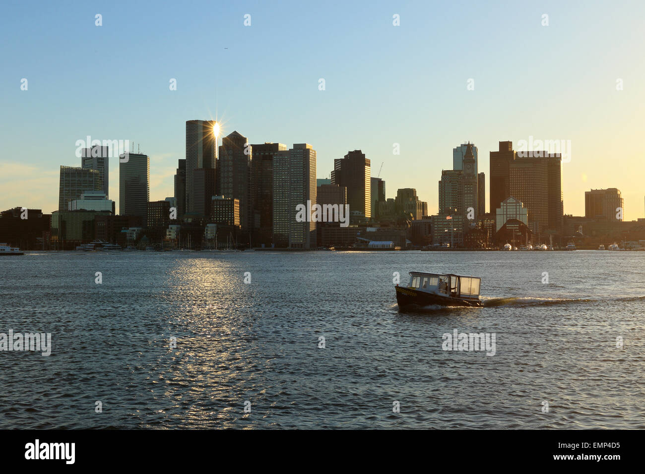Toits de Boston pendant le coucher du soleil avec de belles couleurs du ciel reflétée dans le port de Boston. Banque D'Images