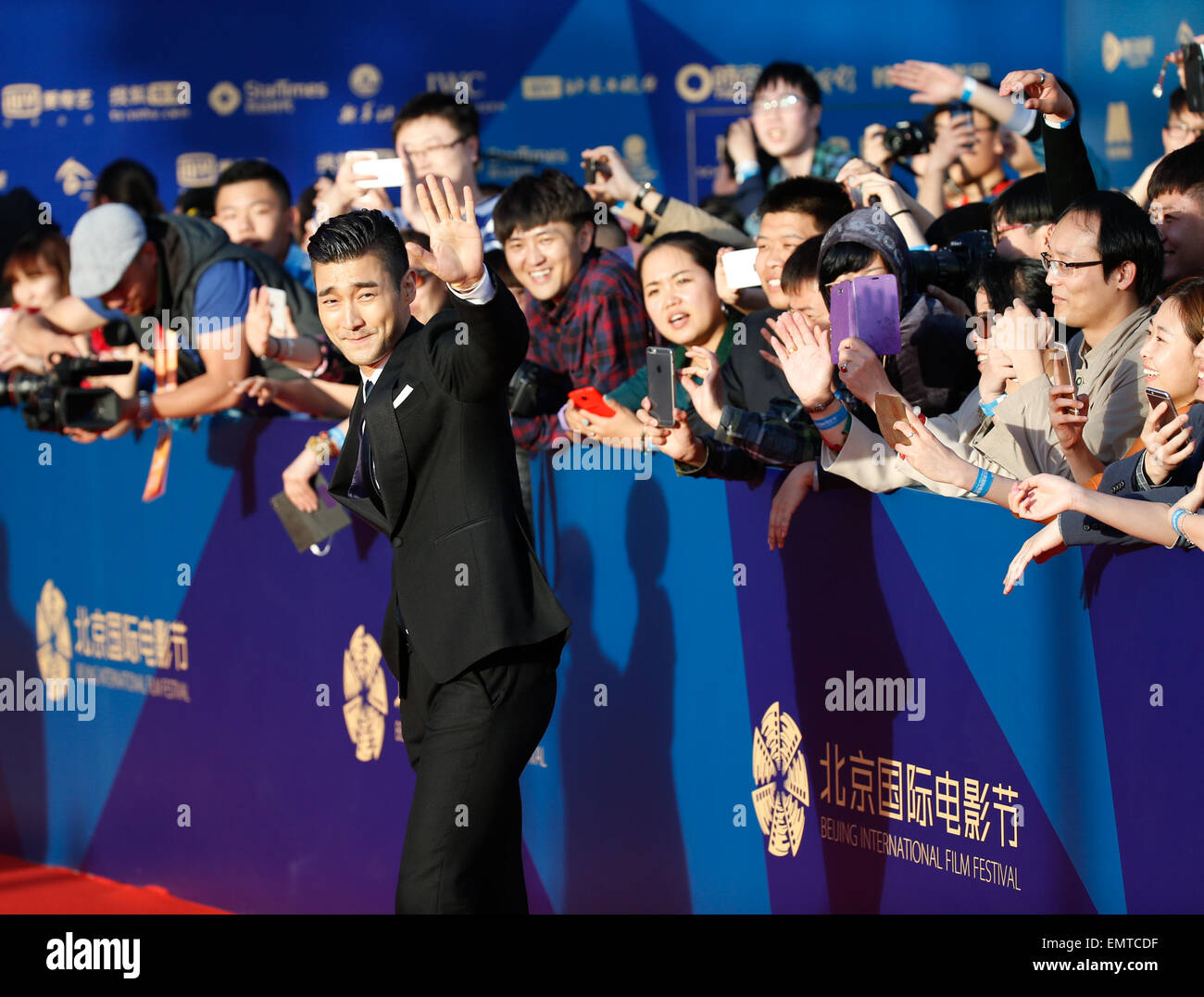 Beijing, Chine. Apr 23, 2015. L'acteur sud-coréen Choi Siwon du film 'Helios' salue la foule pendant qu'il marche le tapis rouge lors de la cérémonie de clôture du 5e Festival International du Film de Beijing (BJIFF) à Beijing, capitale de Chine, le 23 avril 2015. Le BJIFF ici fermé le jeudi. © Shen Bohan/Xinhua/Alamy Live News Banque D'Images