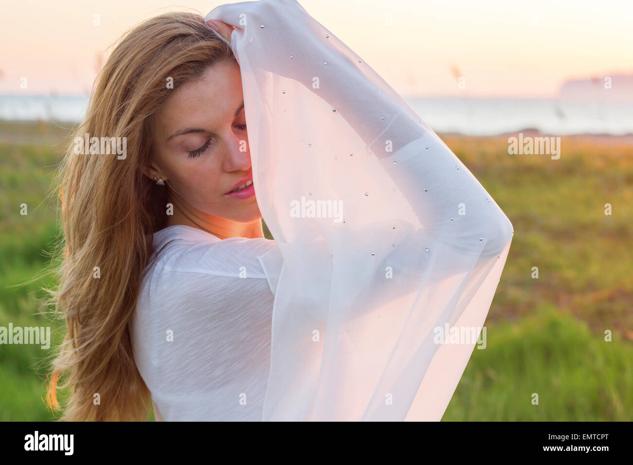 Blonde woman relaxing coucher du soleil campagne pelouse nature mer printemps été Banque D'Images