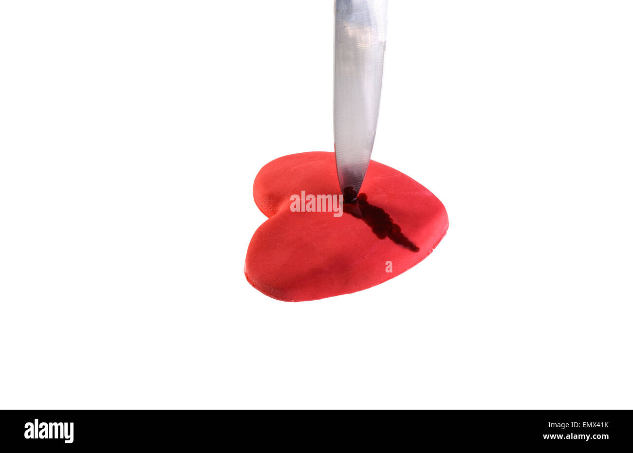 Piercing de couteau un coeur fondant, fait de glaçage. Banque D'Images
