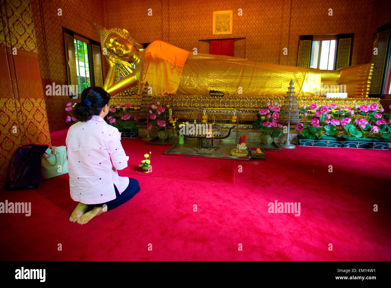 Femme prie silencieusement dans un temple bouddhiste thaïlandais Banque D'Images