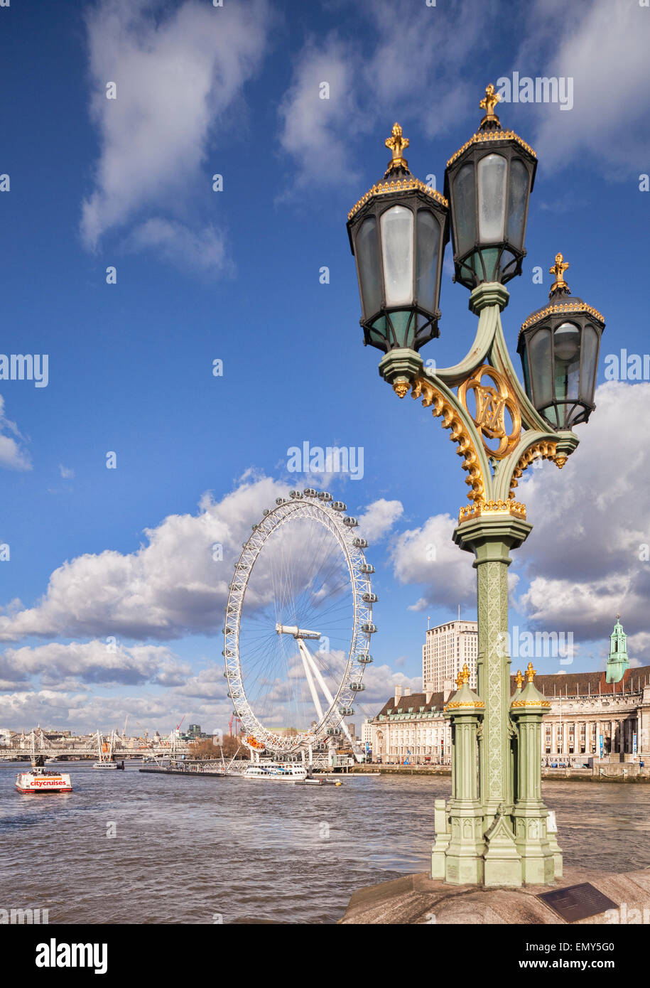 Une lampe standard sur le pont de Westminster avec le London Eye et le County Hall en arrière-plan. Banque D'Images