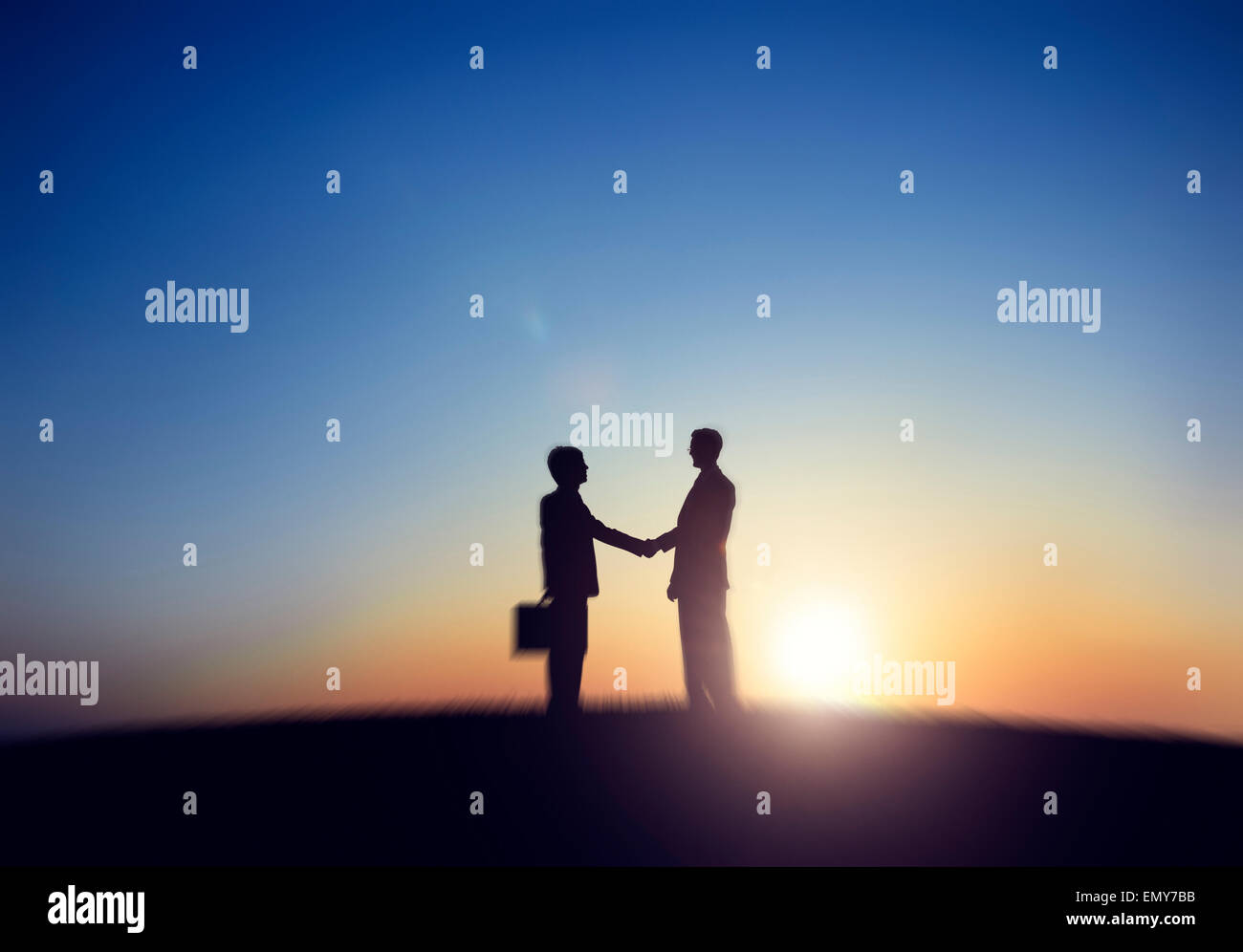 Deux Businessmen Shaking Hand en arrière allumé Banque D'Images
