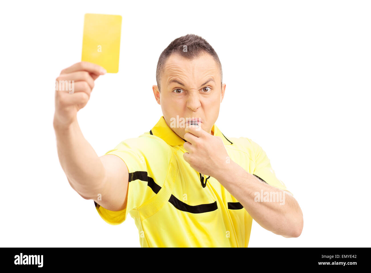 Arbitre de football furieux montrant une carte jaune et en soufflant un sifflet isolé sur fond blanc Banque D'Images