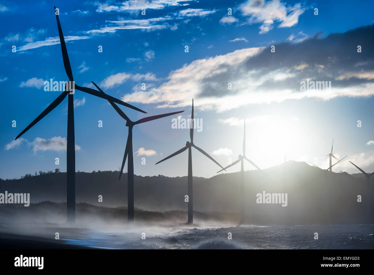 Les générateurs d'énergie éolienne à silhouettes côte de l'océan du soir. La production d'énergie renouvelable de remplacement en Philippines Banque D'Images