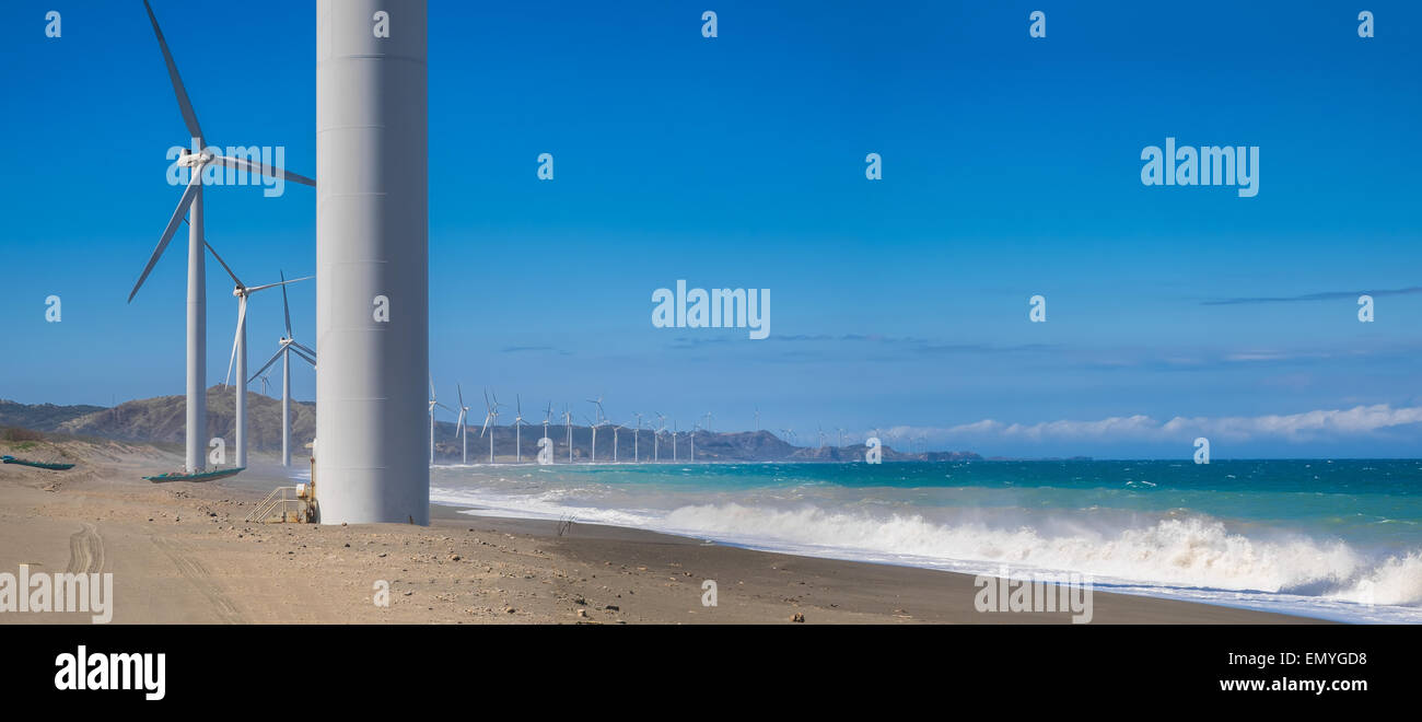 Les générateurs d'énergie éolienne en mer de silhouettes de côte. La production d'énergie renouvelable de remplacement en Philippines Banque D'Images