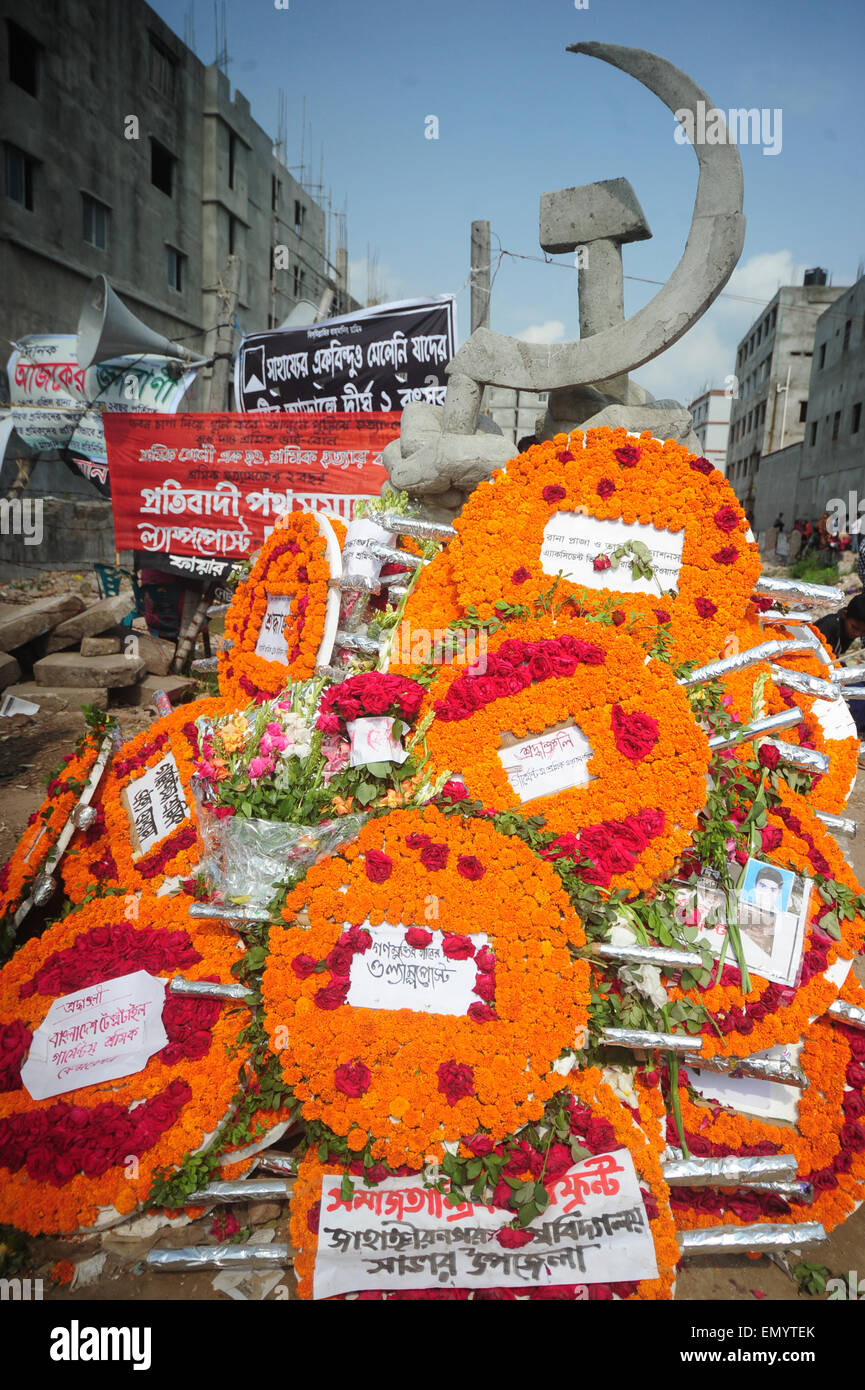 Peuple bangladais jeter des couronnes de fleurs à la mémoire des victimes de l'effondrement des bâtiments du Rana Plaza à l'occasion du deuxième anniversaire de la catastrophe de l'endroit où l'immeuble se trouvait autrefois à Savar, dans la banlieue de Dhaka le 24 avril 2015. Les manifestants, dont des centaines de survivants crièrent d'indemnisation et a exigé la sécurité et les droits du travail dans des milliers d'usines de vêtements qu'ils ont manifesté à l'extérieur de Dhaka pour marquer le deuxième anniversaire de l'un des pires désastres industriels', qui a fait au moins 1 138 morts et plus de 2 500 personnes blessées. Banque D'Images