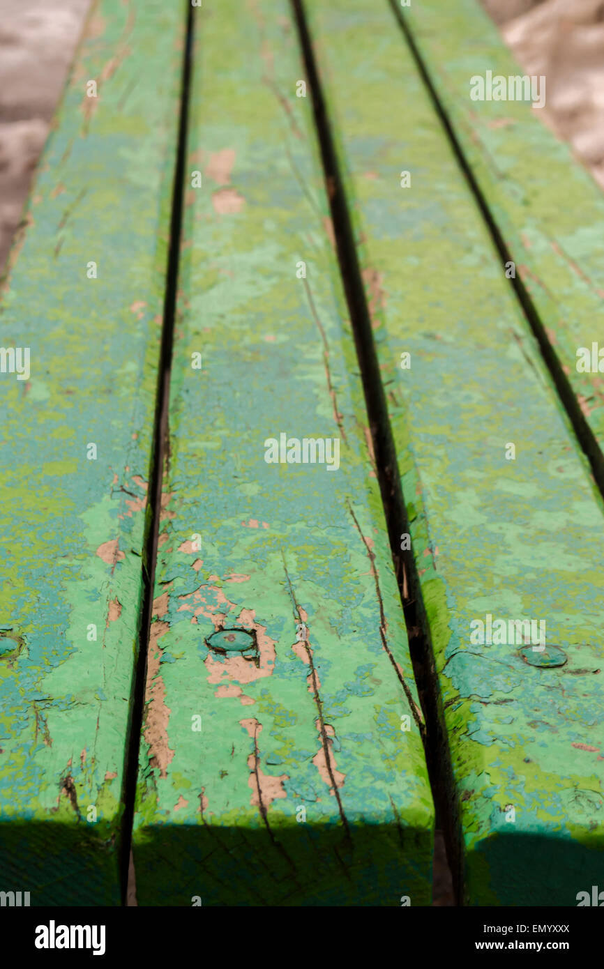 Banc en bois peint en vert avec des poutres apparentes et des clous enfoncés sous couches de déroulage Banque D'Images