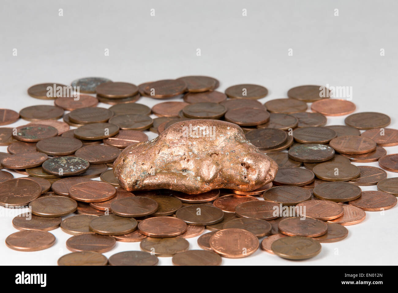 La pépite de cuivre de flottement de la Péninsule Supérieure du Michigan allongé sur un lit de penny. La matière première et le produit fini. Banque D'Images