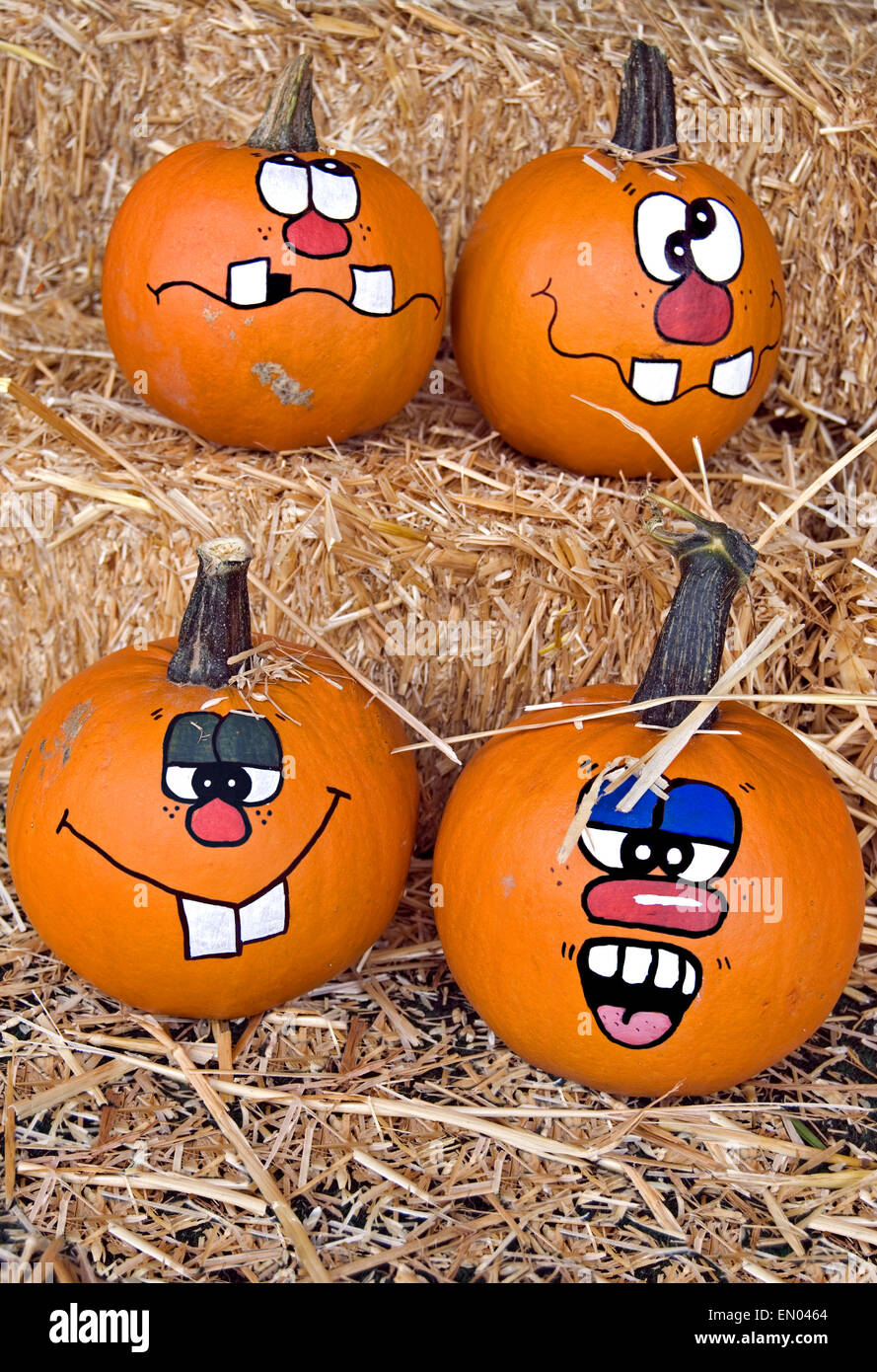 Funny faces peintes sur les citrouilles d'automne des balles de foin. Banque D'Images