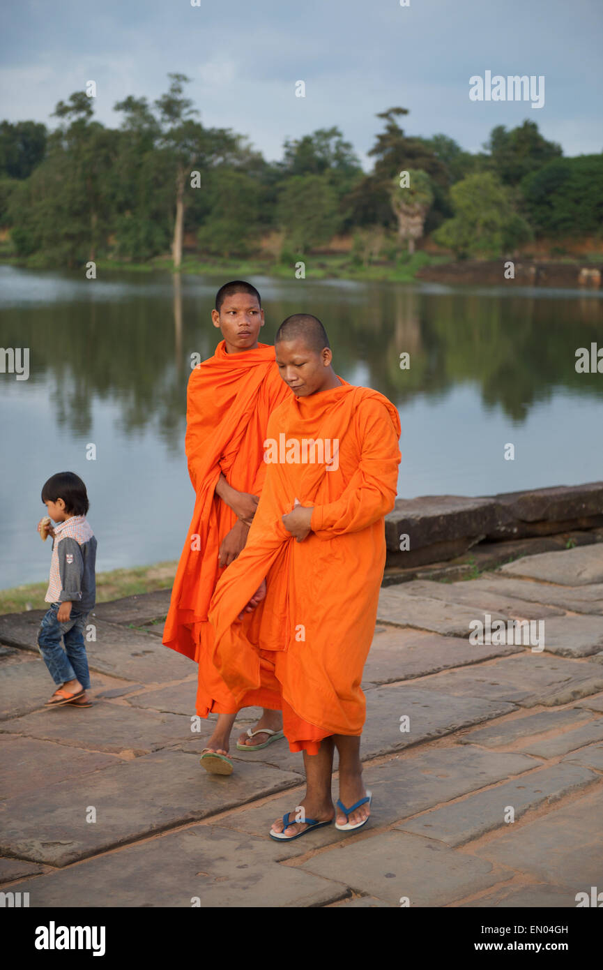 SIEM REAP, Cambodge - 30 octobre 2014 : Novice moines bouddhistes en robe orange marcher pieds nus vers le temple d'Angkor Wat. Banque D'Images