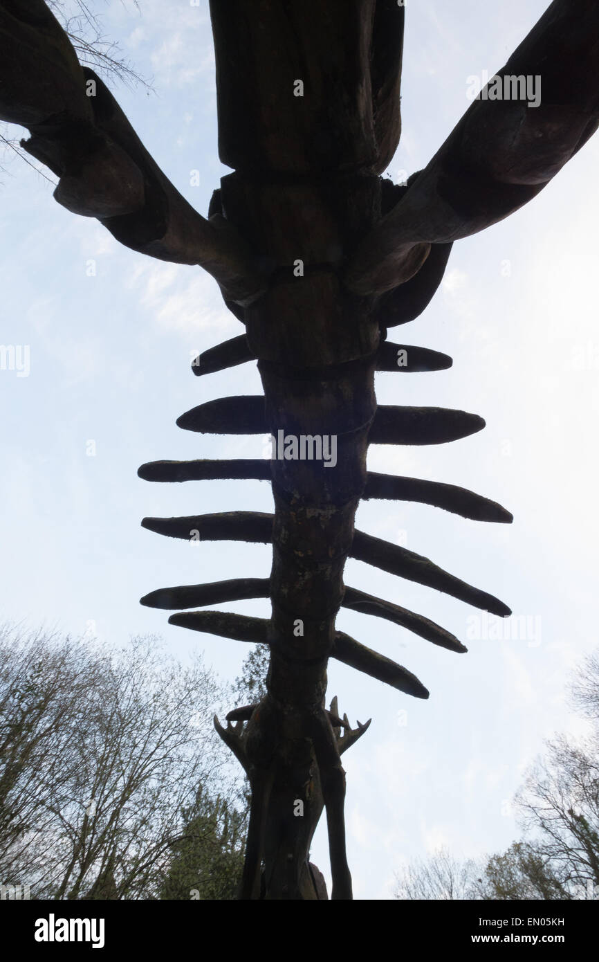 Comme la journée se termine le squelette des structures en bois dans le parc de dinosaures à Wookey Hole caves deviennent plus mystérieux. Banque D'Images
